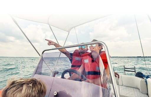 Two people wearing lifejackets while boating. 
